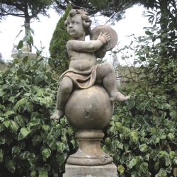 Putto con piatti su sfera in pietra ricostituita corrosa h 99